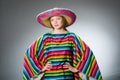 The girl in mexican vivid poncho against gray Royalty Free Stock Photo