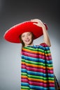 The girl in mexican vivid poncho against gray Royalty Free Stock Photo