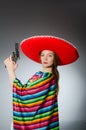 The girl in mexican vivid poncho holding handgun Royalty Free Stock Photo