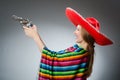 The girl in mexican vivid poncho holding handgun Royalty Free Stock Photo