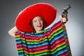 The girl in mexican vivid poncho holding handgun Royalty Free Stock Photo