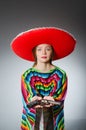 Girl in mexican vivid poncho holding handgun Royalty Free Stock Photo