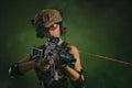 The girl in military overalls airsoft posing with a gun in his hands on a dark background in the haze Royalty Free Stock Photo