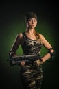 The girl in military overalls airsoft posing with a gun in his hands on a dark background in the haze Royalty Free Stock Photo