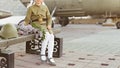 Girl in a military uniform of a Soviet soldier with a bouquet of lilacs on the background of an airplane Royalty Free Stock Photo