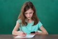 Girl With Mobile Phone Writing On Paper