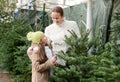 Girl with mom choosing New Year's tree