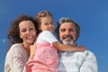 Girl, mother and grandfather smiling and embracing