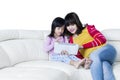 Girl and mother with tablet relaxing on sofa Royalty Free Stock Photo