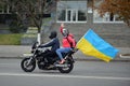 Girl on a motorcycle holding a flag of Ukraine