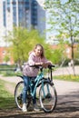 Girl on a mountain bike on urban street, beautiful portrait of a cyclist in sunny weather
