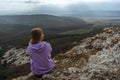 Girl on mountain peak looking at beautiful mountain valley in fog at sunset in summer. Landscape with sporty young woman Royalty Free Stock Photo