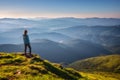 Girl on mountain peak looking at beautiful mountains at sunset