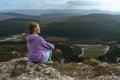 Girl on mountain peak looking at beautiful mountain valley in fog at sunset in summer. Landscape with sporty young woman Royalty Free Stock Photo