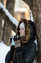 Girl with a mug of tea leaning against a tree and looking straight Royalty Free Stock Photo