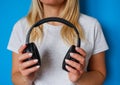 Girl music lover with black wireless headphones on a blue background