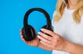 Girl music lover with black wireless headphones on a blue background