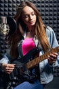 Girl musician in recording studio playing electric guitar Royalty Free Stock Photo