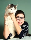 Girl in myopia glasses hug big siberian cat Royalty Free Stock Photo