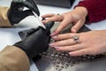 girl nail specialist in hands with a nail file saws the nails of a girl client during