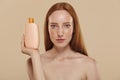 Girl with naked shoulders and lotion or shampoo