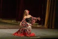 A girl in a national dress dances a gypsy dance