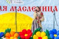 A girl in national dress sings on the stage at the holiday Maslenitsa. Russian text: Parks of Samara Maslenitsa