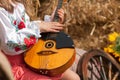 Girl in national Ukrainian suit holds the domra