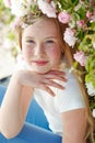 Girl on the nature of a rose. Beautiful red-haired girl near roses.