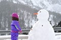 The girl near a big snowman.