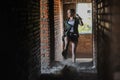 Girl near the brick wall in military style.