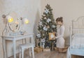 The girl near the Christmas tree with gifts