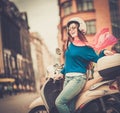 Girl near scooter in in european city