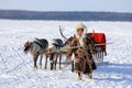A girl of the Nenets people leads a reindeer sled across the Arctic tundra