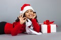 Girl with a New Year gift. Joyful girl in a cap of Santa Claus