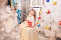 Girl in a New Year& x27;s dress near the Christmas tree Royalty Free Stock Photo