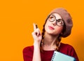 Girl with notebook and pencil on yellow background. Royalty Free Stock Photo