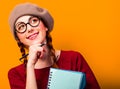 Girl with notebook and pencil on yellow background. Royalty Free Stock Photo