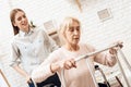 Girl is nursing elderly woman at home. Woman is trying to stand up from wheelchair. Royalty Free Stock Photo