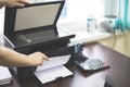 Girl in the office prints documents on a printer. Royalty Free Stock Photo