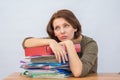 Girl office staff thoughtfully leaning on a stack of folders Royalty Free Stock Photo