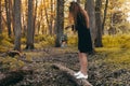 Girl with oil lamp is walking at the wilderness and looking for. Dark forest, evening. Summer time. Travel story