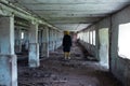 A girl in an old abandoned scary room like a barn or stable. An abandoned factory barn and stable where cows and horses Royalty Free Stock Photo