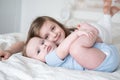 Girl older sister hugging her little baby boy brother on bed at home Royalty Free Stock Photo