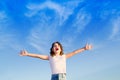 Girl open arms outdoor under blue sky