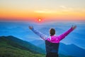 Girl with open arms standing over the mountains and looking to the summer sunset Royalty Free Stock Photo