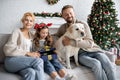 Girl opening christmas present near parents