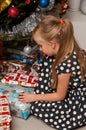 Girl opening Christmas present under Christmas tree Royalty Free Stock Photo