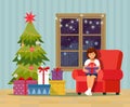 Girl opening a gift at home in the living room. Christmas room interior with Christmas tree, sofa, gifts and decoration. Royalty Free Stock Photo