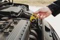 Girl opening the hood of her car checks the engine oil level